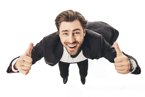 Close-up shot of smiling young businessman falling and showing thumbs up isolated on white — Stock Photo