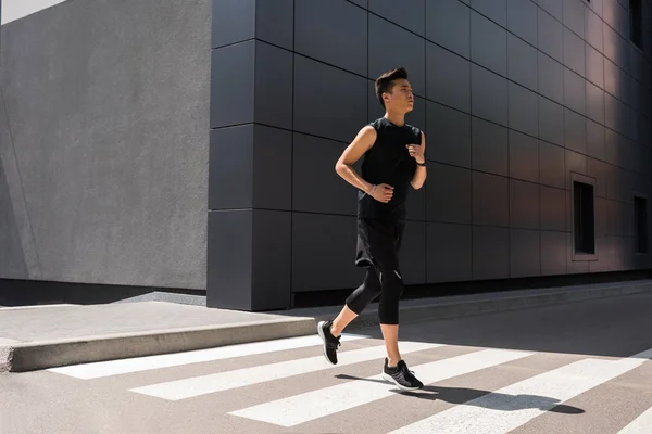 Beau jeune asiatique sportif courir à urbain rue — Photo de stock