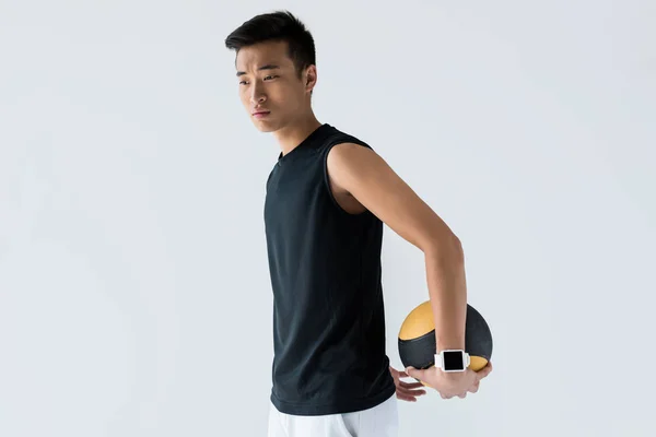 Jeune sportif asiatique avec smartwatch tenant médecine ballon isolé sur fond gris — Photo de stock
