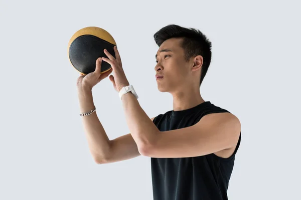 Vista lateral de jovem asiático desportista com medicina bola isolada no fundo cinza — Fotografia de Stock
