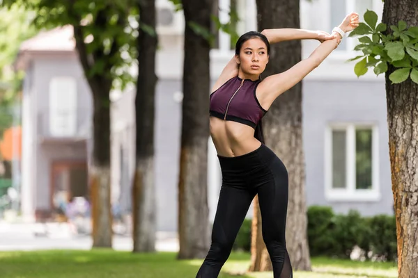 Attraente asiatico sportswoman stretching in parco — Foto stock