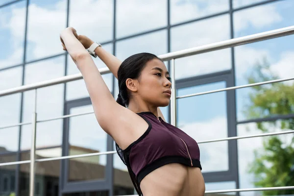 Young asian sportswoman stretching at city street — Stock Photo