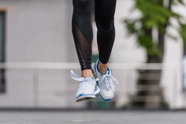 Abgeschnittenes Bild einer Sportlerin, die auf städtischer Straße läuft — Stockfoto