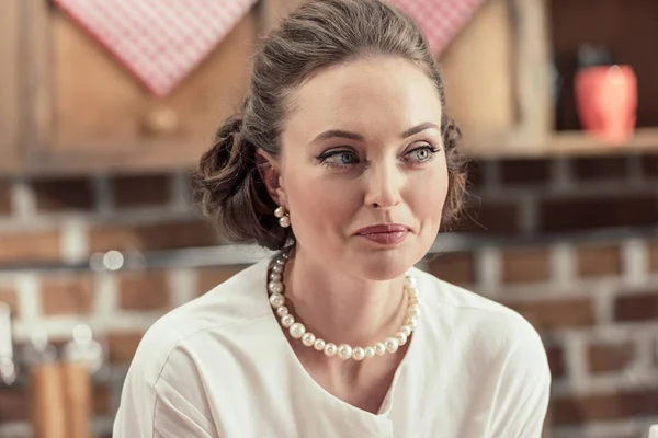 Nahaufnahme Porträt einer lächelnden erwachsenen Frau in stilvoller Vintage-Kleidung und Perlenkette, die wegschaut — Stockfoto