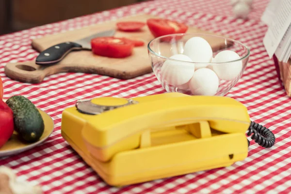 Крупным планом винтажный телефон с различными овощами и куриными яйцами на столе — Stock Photo