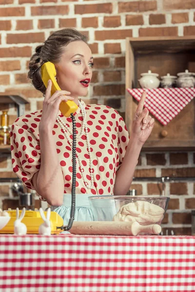 Sorpresa casalinga adulta con idea creativa parlando per telefono e indicando la cucina — Foto stock