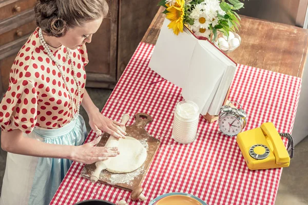 Vista ad alto angolo di bella casalinga adulta impastare pasta con mattarello in cucina — Foto stock