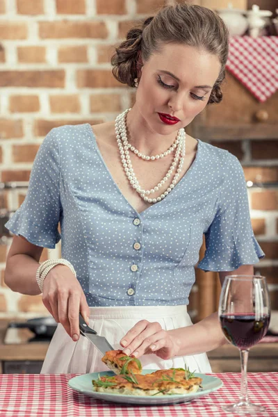 Belle femme au foyer adulte coupe gâteau aux champignons frais à la cuisine — Photo de stock