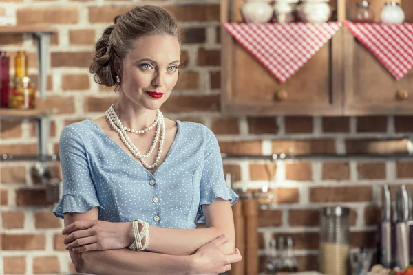 Confiante femme au foyer adulte en vêtements vintage debout à la cuisine et regardant loin — Photo de stock