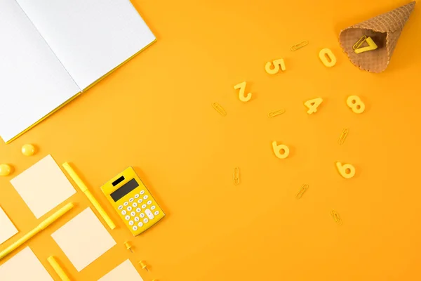 Vista dall'alto di notebook in bianco con vari materiali di studio e cono waffle su giallo — Foto stock