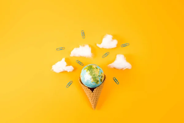 Top view of earth globe in waffle cone with clouds made of cotton on yellow — Stock Photo