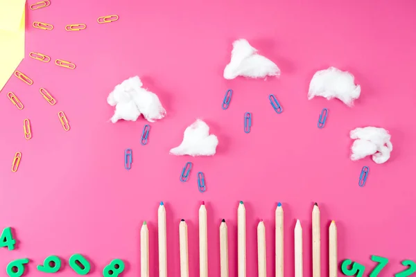 Top view of rainy landscape composition arranged of paper clips, pencils and cotton on pink — Stock Photo