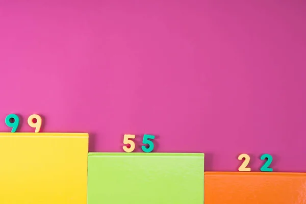 Draufsicht auf bunte Notizbücher und Mathe-Zahlen auf rosa — Stockfoto