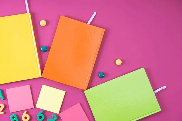 Flat lay with colorful notebooks and appliances on pink — Stock Photo