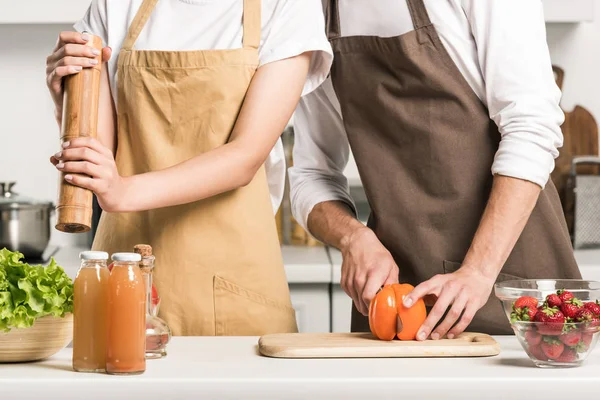 Cropped image of couple cooking salad in kitchen — Stock Photo