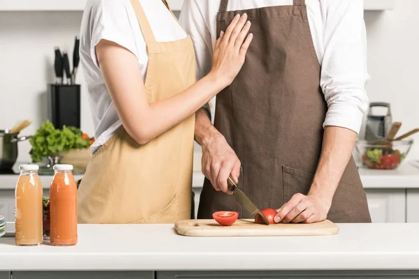 Imagem cortada de casal preparando salada e cortando tomates na cozinha — Fotografia de Stock