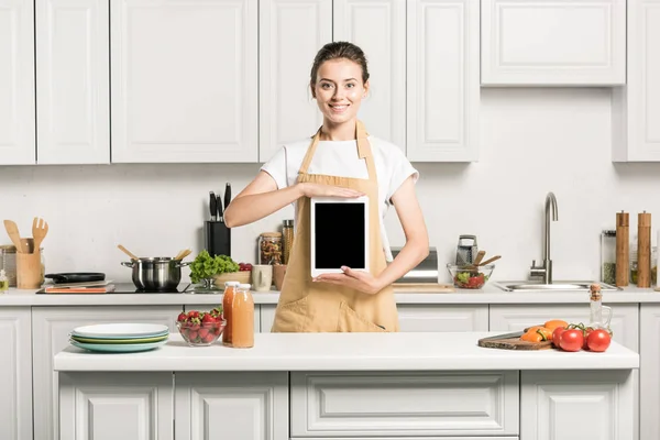 Attractive girl holding tablet with blank screen in kitchen — Stock Photo