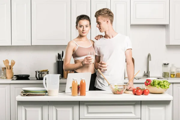 Jovem casal abraçando perto do balcão da cozinha — Fotografia de Stock