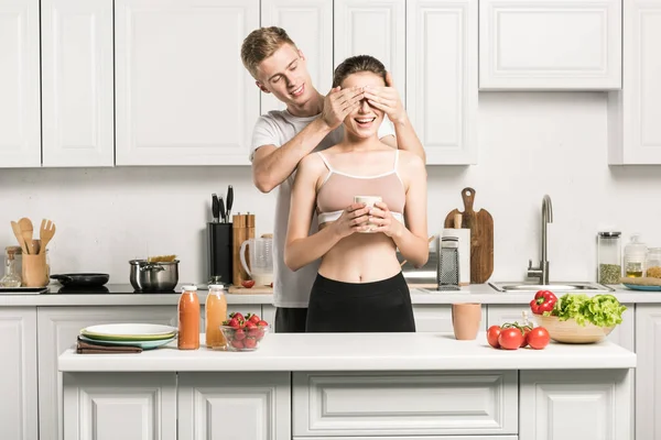 Namorado fechar os olhos para namorada na cozinha — Fotografia de Stock