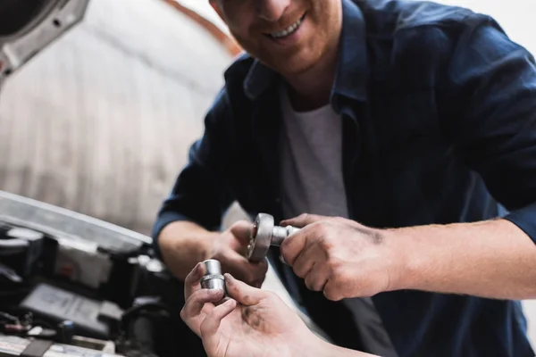 Imagem cortada de pai e filho reparando carro com capuz aberto e segurando ferramentas — Fotografia de Stock