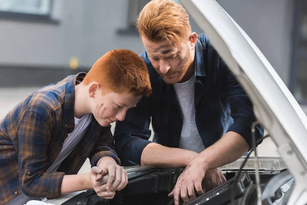 Vater und Sohn reparieren Auto und schauen in offene Motorhaube — Stockfoto