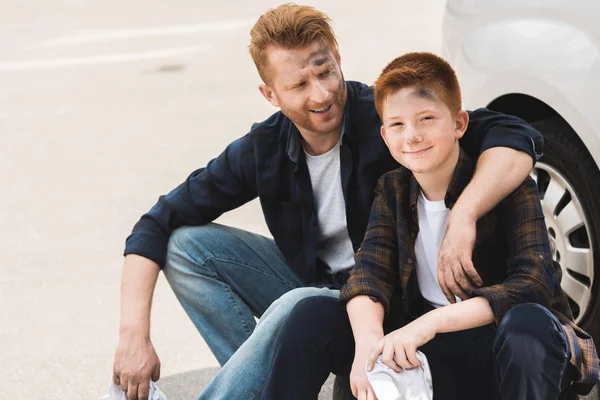 Dirty happy father hugging son after repairing car — Stock Photo