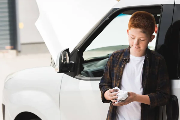 Red hair preteen boy repairing car and holding napkin — Stock Photo