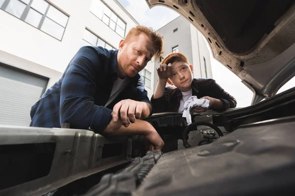 Müder dreckiger Vater und Sohn reparieren Auto — Stockfoto