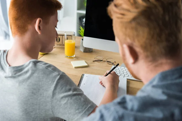 Father helping son doing homework at home — Stock Photo