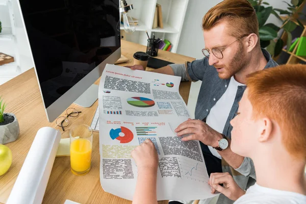 Father and son looking at diagram at home — Stock Photo