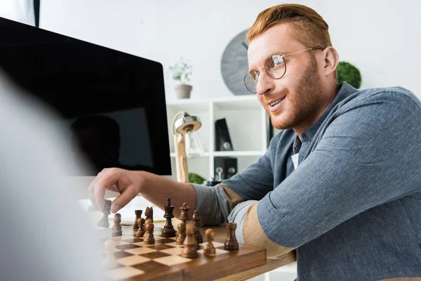 Pai jogando xadrez e olhando para o filho em casa — Fotografia de Stock