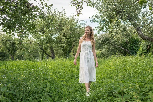 Beautiful elegant woman in apple garden — Stock Photo