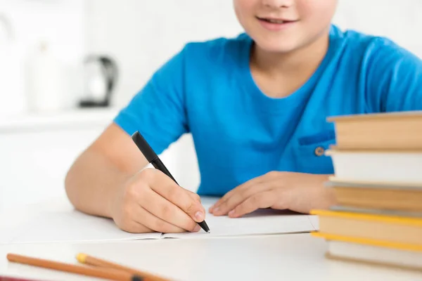 Visão parcial da escrita do menino no copybook ao fazer o dever de casa em casa — Fotografia de Stock