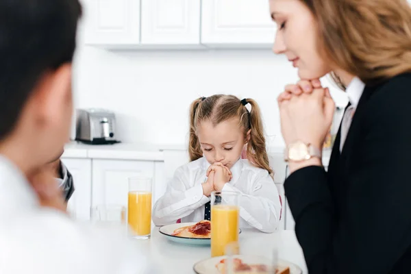 Partial view of family praying together during breakfast at home — Stock Photo