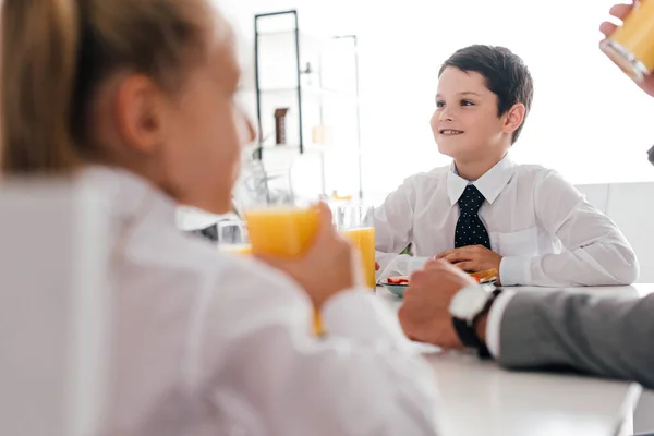 Vista parziale di padre e figli in uniforme scolastica che fanno colazione a casa — Foto stock
