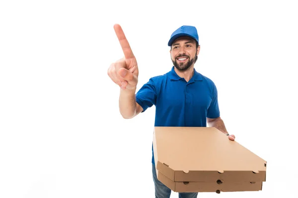 Happy delivery man holding boxes with pizza and pointing with finger isolated on white — Stock Photo