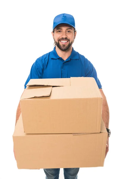 Bonito feliz jovem entrega homem segurando caixas de papelão e sorrindo para a câmera isolada no branco — Fotografia de Stock