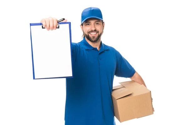 Guapo feliz joven repartidor hombre sosteniendo caja de cartón y portapapeles en blanco aislado en blanco - foto de stock