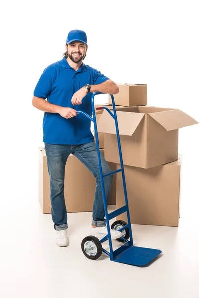 Full length view of handsome happy delivery man smiling at camera isolated on white — Stock Photo
