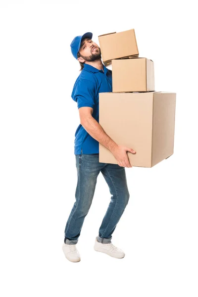 Full length view of tired delivery man holding stacked cardboard boxes and looking at camera isolated on white — Stock Photo