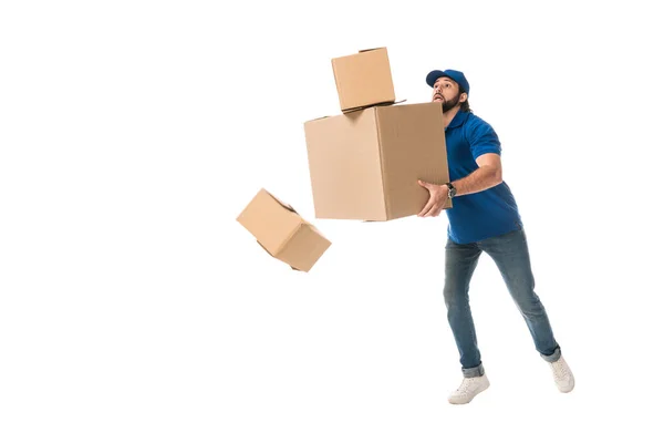 Full length view of delivery man holding stacked cardboard boxes falling isolated on white — Stock Photo