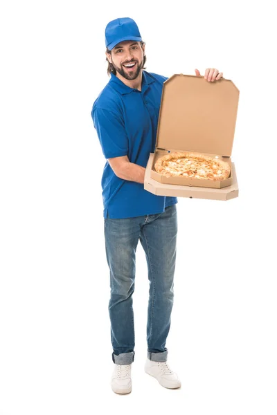 Guapo repartidor sosteniendo pizza en cajas y sonriendo a cámara aislada en blanco - foto de stock