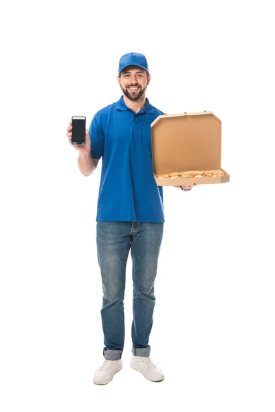 Happy delivery man holding smartphone and pizza in box, smiling at camera isolated on white — Stock Photo
