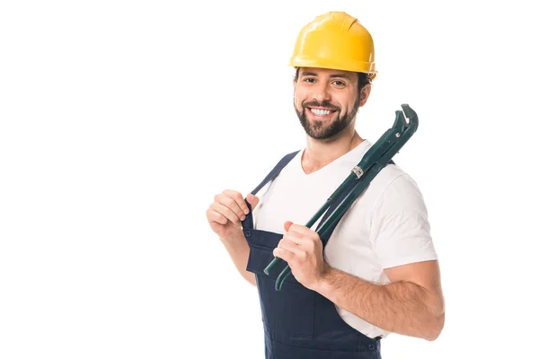 Schöner glücklicher Arbeiter, der einen verstellbaren Schraubenschlüssel in der Hand hält und isoliert auf weiß in die Kamera lächelt — Stockfoto