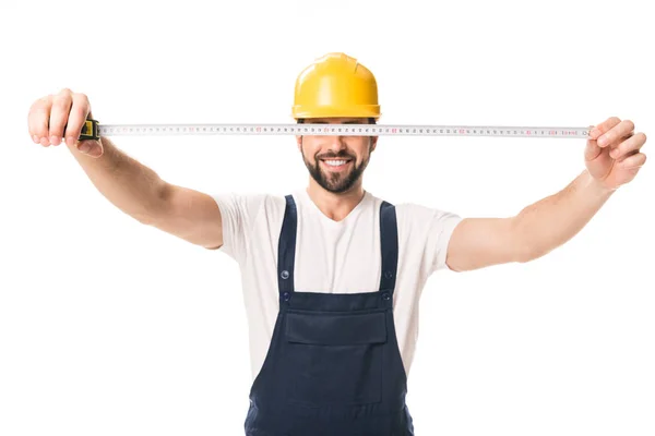 Handsome happy workman holding measuring tape isolated on white — Stock Photo