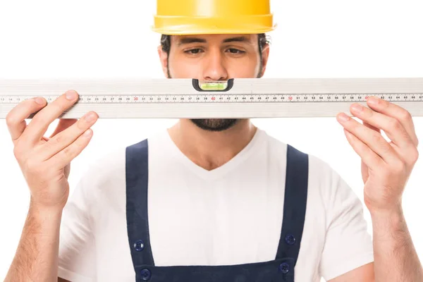 Trabajador de la construcción guapo en herramienta de nivel de retención de sombrero duro aislado en blanco - foto de stock