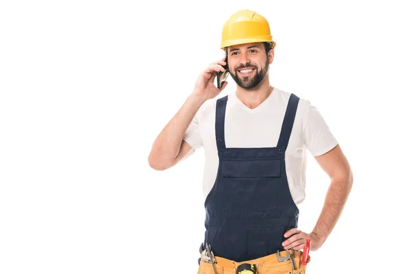 Happy handsome construction worker in hard hat talking by smartphone isolated on white — Stock Photo