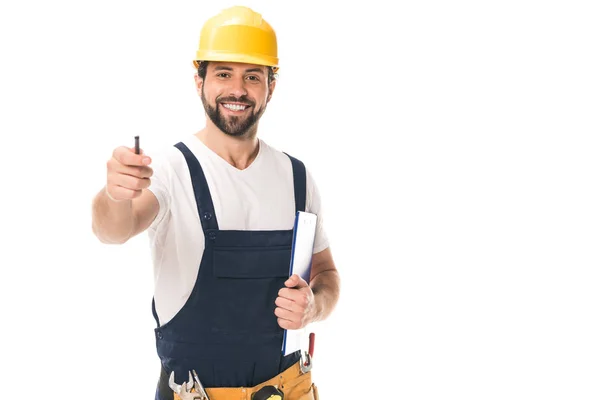 Trabajador de la construcción guapo en sombrero duro sujetando portapapeles y sonriendo a la cámara aislada en blanco - foto de stock