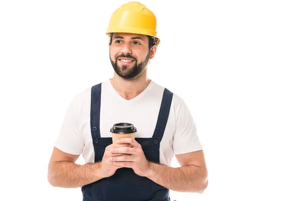 Handsome smiling workman in hard hat holding coffee to go and looking away isolated on white — Stock Photo