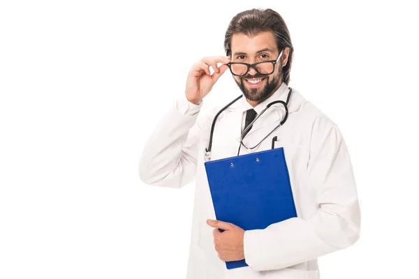 Doctor with clipboard adjusting eyeglasses and smiling at camera isolated on white — Stock Photo